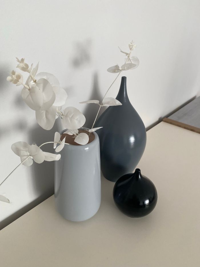 Minimalist arrangement of ceramic vases with white artificial flowers, perfect for modern decor.