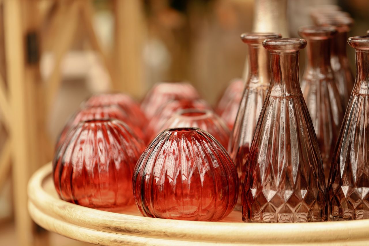 A collection of ornate red glass vases displayed on a wooden tray, perfect for home decoration.